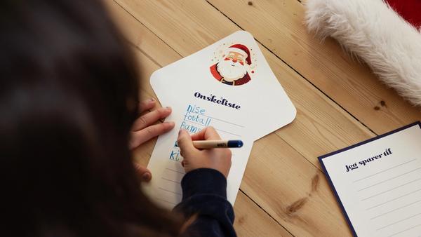 Jente med mørkt hår som skriver ønskeliste til jul