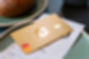 Et Mastercard i gull ligger sammen med en kvittering på et fat på et spisested