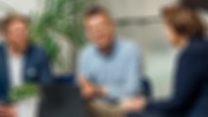 Tre rådgivere fra Sparebanken Møre sitter i en sofa og diskuterer. Personen i midten smiler til deg.